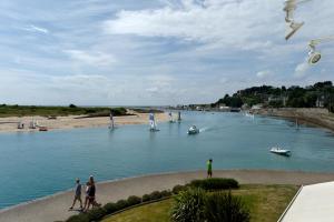 a group of people on a river with boats in the water at Hôtel La Marine - Restaurant Marnage in Barneville-Carteret