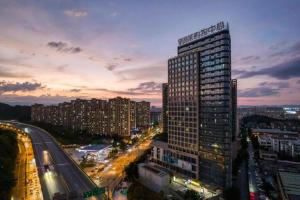 a tall building in a city at night at Hangzhou Wangzhou Boutique Hotel in Yuhang