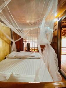 een slaapkamer met een bed met een klamboe bij ThongDong Homestay in Hữu Lũng