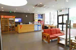 a store lobby with a red couch and a counter at 7 Days Premium Beijing Dabaotai Metro Station Luhua Road in Beijing