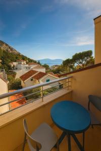a balcony with a blue table and chairs at Hotel Neptun Gradac in Gradac