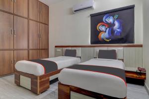 two beds in a room with a painting on the wall at Collection O Hyderabad Hitech City Formerly Night Eye in Hyderabad