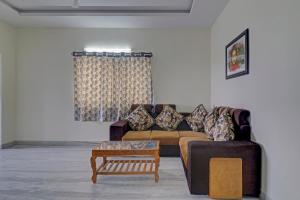 a living room with a couch and a coffee table at Collection O Hyderabad Hitech City Formerly Night Eye in Hyderabad