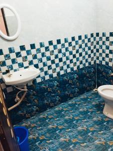 a fish themed bathroom with a sink and a toilet at Hotelroyalcrown in Jāmb