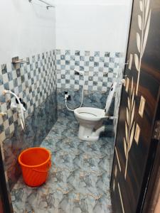 a bathroom with a toilet and a bucket in it at Hotelroyalcrown in Jāmb