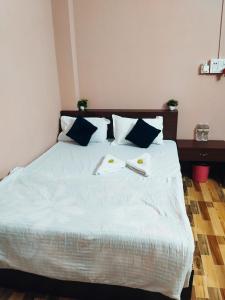 a bedroom with a bed with two books on it at Hotelroyalcrown in Jāmb