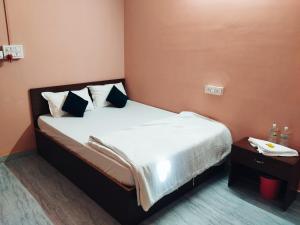 a bedroom with a bed and a table with a telephone at Hotelroyalcrown in Jāmb