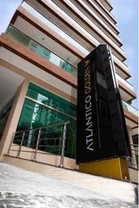 un edificio con una gran señal delante de él en Atlântico Golden Apart Hotel, en Santos