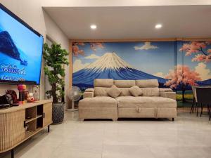 a living room with a couch and a large tv at Konijiwa Bangsaen Private Pool Karaoke BBQ in Ban Muang (1)