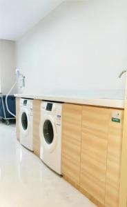 a row of washing machines in a room at City Comfort Inn Wuhan Hangkong Road Tongji Hospital in Wuhan