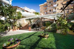 un jardin avec deux pots de fleurs sur l'herbe dans l'établissement Angiolina Relais, à Sorrente