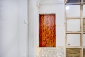 a wooden door in a room with two windows at Super Collection O Police Bazar Shillong Formerly Pillars House in Shillong +24 photos