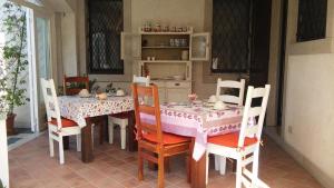 ein Esszimmer mit einem Tisch und Stühlen sowie einem Tisch und einem Stuhl in der Unterkunft B&B Casa Perini in Villa Vicentina
