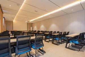 ein Konferenzraum mit Tischen und Stühlen in der Unterkunft City Comfort Inn Jinan West Station Shandong International Convention and Exhibition in Jinan