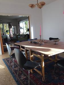 een eetkamer met een houten tafel en stoelen bij Villa Insikt Pensionat & Kursgård in Burträsk