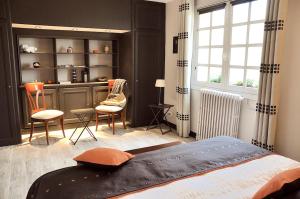 a bedroom with a bed and a table and chairs at Au Jardin de Lisa in Cherreau