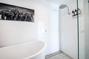 a bathroom with a white tub and a picture of elephants at Daisy's Lodge - Relaxed & Family-Friendly Stay in Dubbo