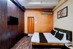 a hotel room with a bed and a television at Collection O Lokmanya Nagar Metro Station Formerly Hotel Siddhivinayak in Rāipur +18 photos