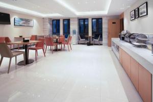 City Comfort Inn Changsha Outlets Datuo Metro Station في تشانغشا: غرفة طعام مع طاولات وكراسي في مطعم