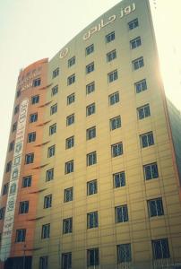 a large building with a sign on the side of it at Rose Garden Hotel in Riyadh