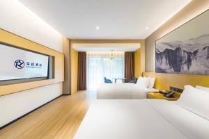 ein Hotelzimmer mit zwei Betten und einem Flachbildfernseher in der Unterkunft Starway Hotel Chongqing Nanbin Road Riverview in Chongqing