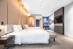 Ένα ή περισσότερα κρεβάτια σε δωμάτιο στο Atour Hotel Wuhan Donghu Yuejiazui