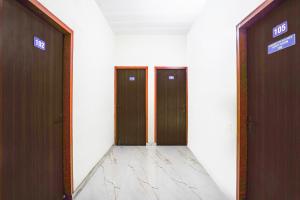 een hal met twee bruine deuren in een gebouw bij Hotel O Madhur Milap in Sohna