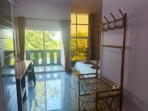 a bedroom with a bed and a balcony with a window at VibeHostel in Kampot