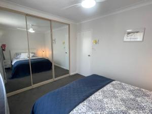 a bedroom with a bed and a large mirror at Ocean View from Balcony - Xmas by the Sea in Port Macquarie