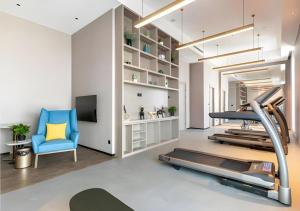 a gym with a treadmill and a blue chair at Premier City Comfort Hotel Quanzhou Wanda Plaza in Quanzhou