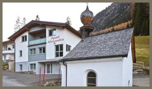 un gran edificio blanco con una torre encima en Apart Alexandra, en Ischgl