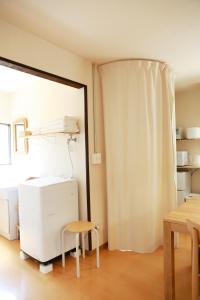 a room with a refrigerator and a table and a window at MINI HOTEL totonoi ロウリュ式サウナのある静かな平屋 in Shimonoseki