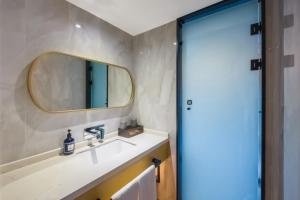 ein Badezimmer mit Waschbecken und Spiegel in der Unterkunft Starway Hotel Chongqing Nanbin Road Riverview in Chongqing + 44 Fotos