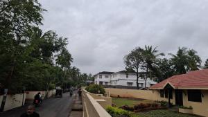 a street with houses and people walking down the street at Aagneyam Grand Resort in Kozhikode