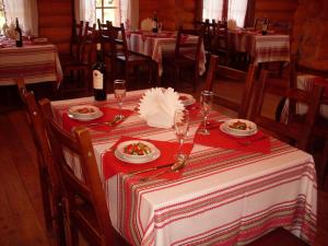 einen Tisch mit Teller mit Lebensmitteln auf einem roten und weißen Tischtuch in der Unterkunft Solovki Hotel in Solowezki-Inseln
