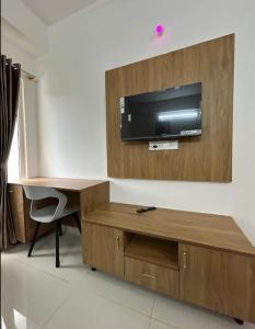 a room with a desk and a television on a wall at The Grand Inn - Kempegowda Airport Bangalore in Devanhalli +8 photos