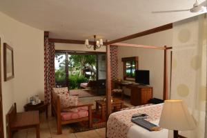 1 dormitorio con 1 cama y sala de estar en Baobab Beach Resort & Spa, en Diani Beach