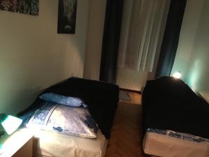a bedroom with two beds and a table and a window at Rosmarinus Apartman in Pécs