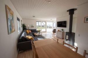 a living room with a couch and a wood stove at Cottage With Panoramic View Of Lammefjorden in Holbæk