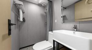 a bathroom with a white toilet and a sink at Shell Hotel Beijing Shunyi District Shunyi Metro Station in Tahe +96 photos