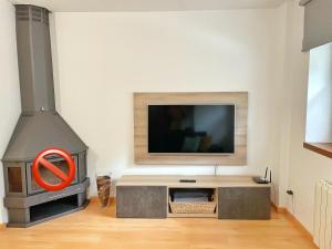 a living room with a tv and a stove at Apartamento Casa Chloe in Benasque