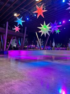 a ice skating rink with colorful stars hanging from the ceiling at Available Dec 23 & 24 Cascade Lodge suite hot tubs pool gym sauna WIFI cable TV ski storage room in Whistler +33 photos