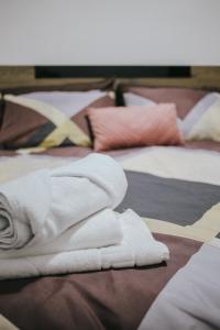 a pile of white towels sitting on top of two beds at Hypogeon Residence in Bitola