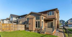 a house with a fence in a yard at Evanston House in Calgary