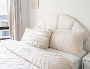 - un lit blanc avec des oreillers blancs et une fenêtre dans l'établissement Tropical Oasis-Luxury Apartment, à Trevallyn