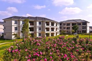 un grand immeuble d'appartements avec des fleurs roses au premier plan dans l'établissement Tropical Oasis-Luxury Apartment, à Trevallyn