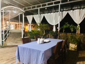 a table with a blue table cloth and white curtains at Kthorm Nesat Koh Kong in Phumĭ Stœ̆ng Vêng +7 photos