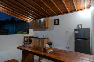 a kitchen with a wooden table and a refrigerator at Arta Bali Glamping in Tianyar