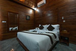 a bedroom with a large bed with wooden walls at Arta Bali Glamping in Tianyar