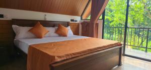 een slaapkamer met een bed en een groot raam bij Pinna Eco in Galle